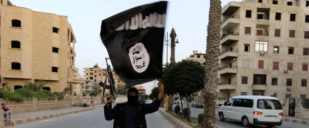 A member loyal to the ISIL waves an ISIL flag in Raqqa